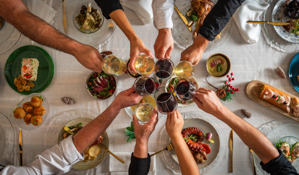 Personas brindando en una mesa con platos de comida variada en Tenerife.