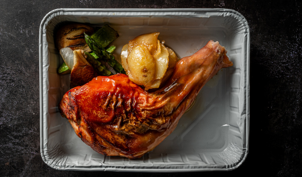 Pollo asado con verduras y papas en bandeja de aluminio en Tenerife.