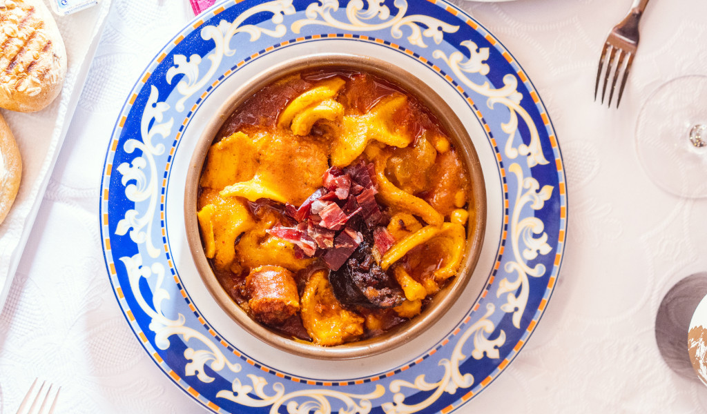 Potaje de Tenerife con garbanzos en plato decorativo, servido en mesa.