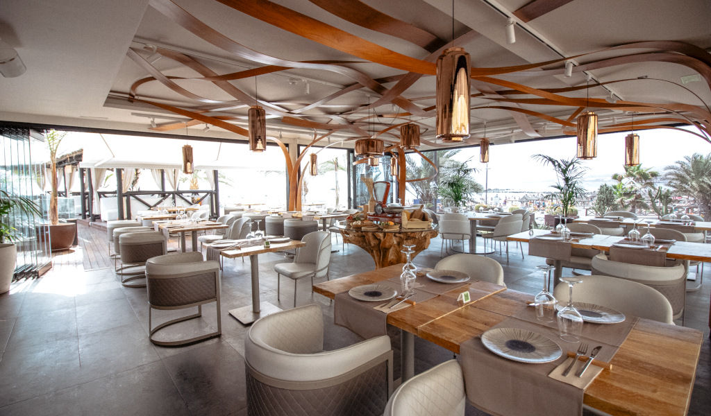 Restaurante elegante con vista al mar en Tenerife, mesas preparadas para comensales.