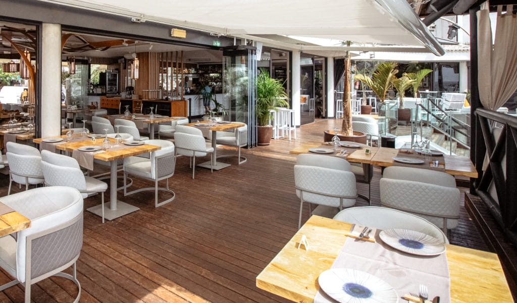Terraza de restaurante en Tenerife con mesas y sillas, decoración moderna.