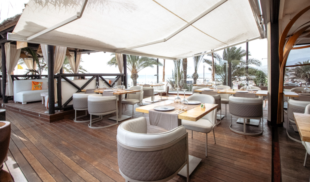 Terraza de restaurante con vistas al mar y mesas al aire libre en Tenerife.
