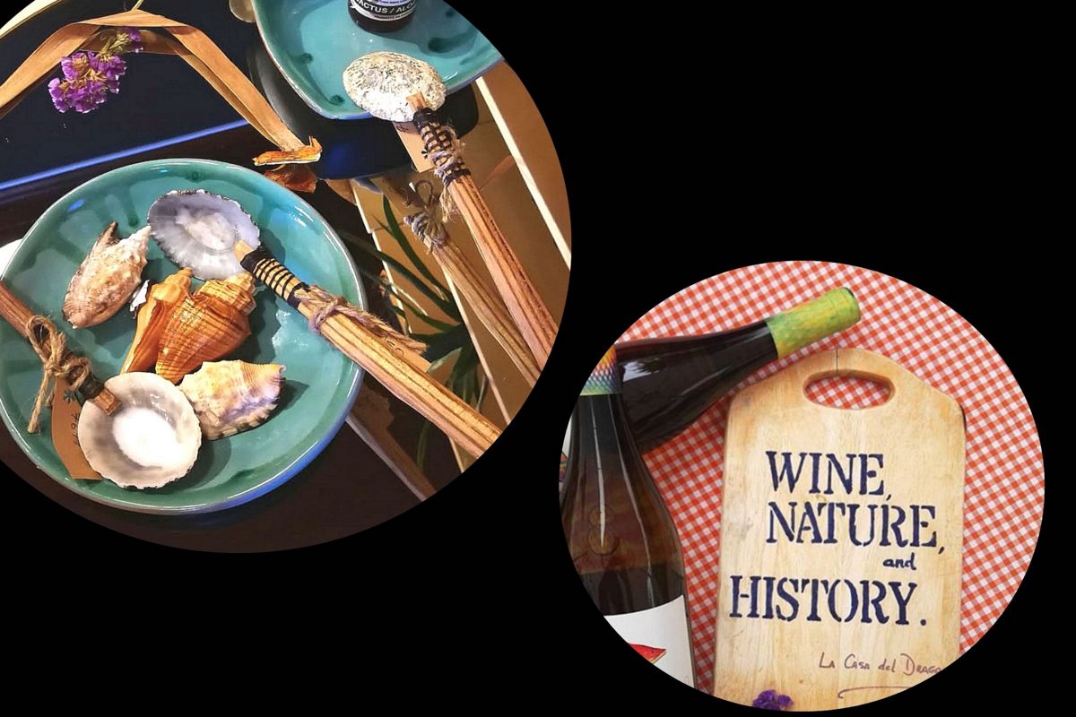 Platos de conchas y botella junto a tabla con texto WINE, NATURE, and HISTORY en Tenerife.