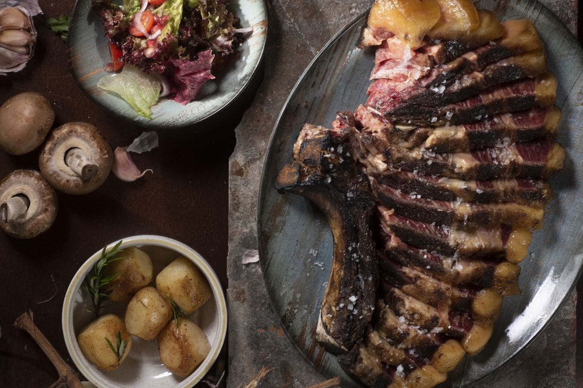 Entrecot asado con ensalada y papas en un plato en Tenerife.