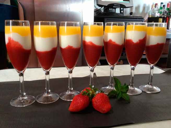 Vasos de postre con capas de fresa y mango junto a fresas en Tenerife.