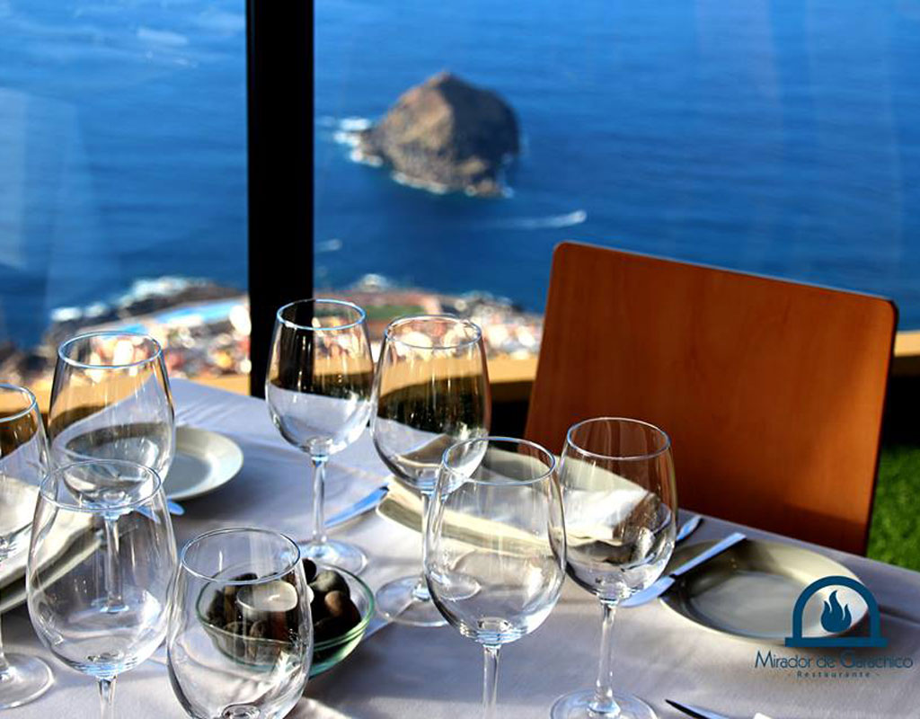 Mesa con copas y platos, vista al mar desde el Mirador de Garachico, Tenerife.