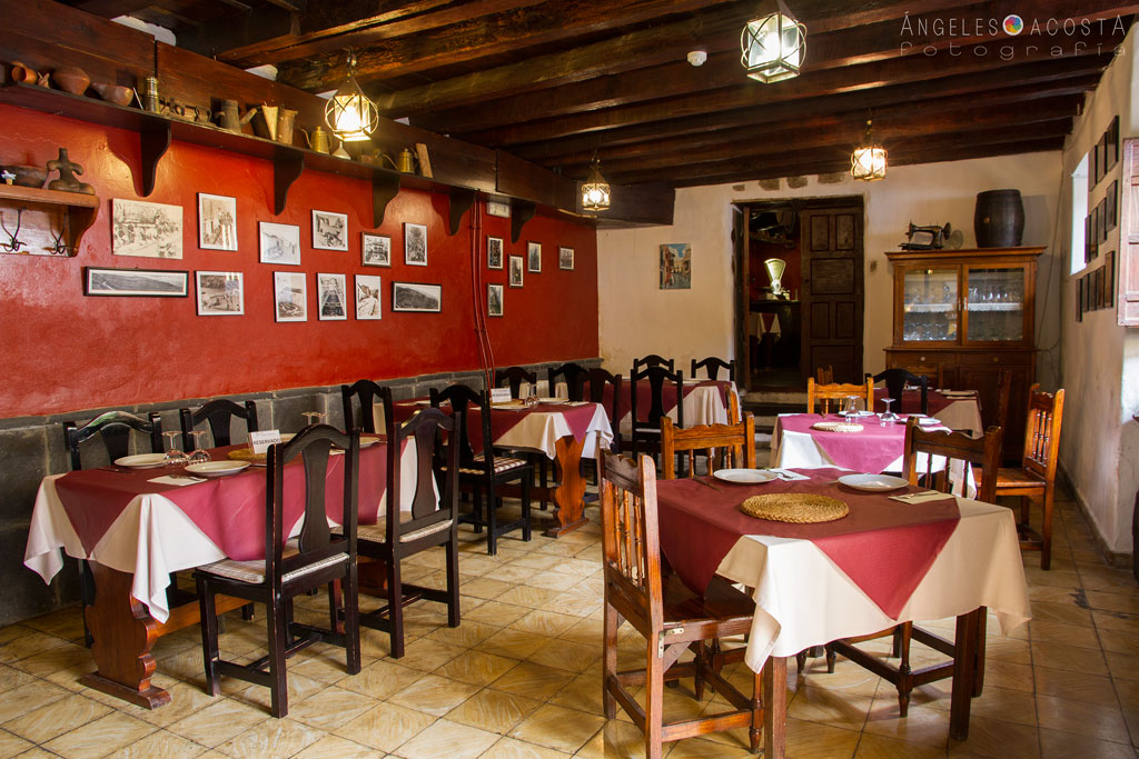 Comedor rústico de restaurante en Tenerife con mesas decoradas.