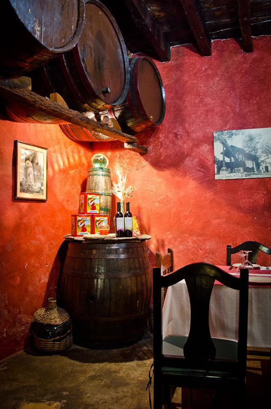 Barriles y mesa en bodega tradicional en Tenerife. Botellas de vino sobre barril de madera.