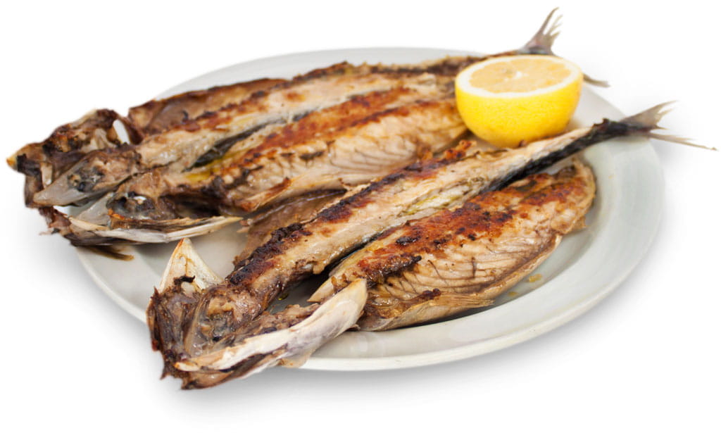 Caballas asadas en un plato con medio limón, típica comida de Tenerife.