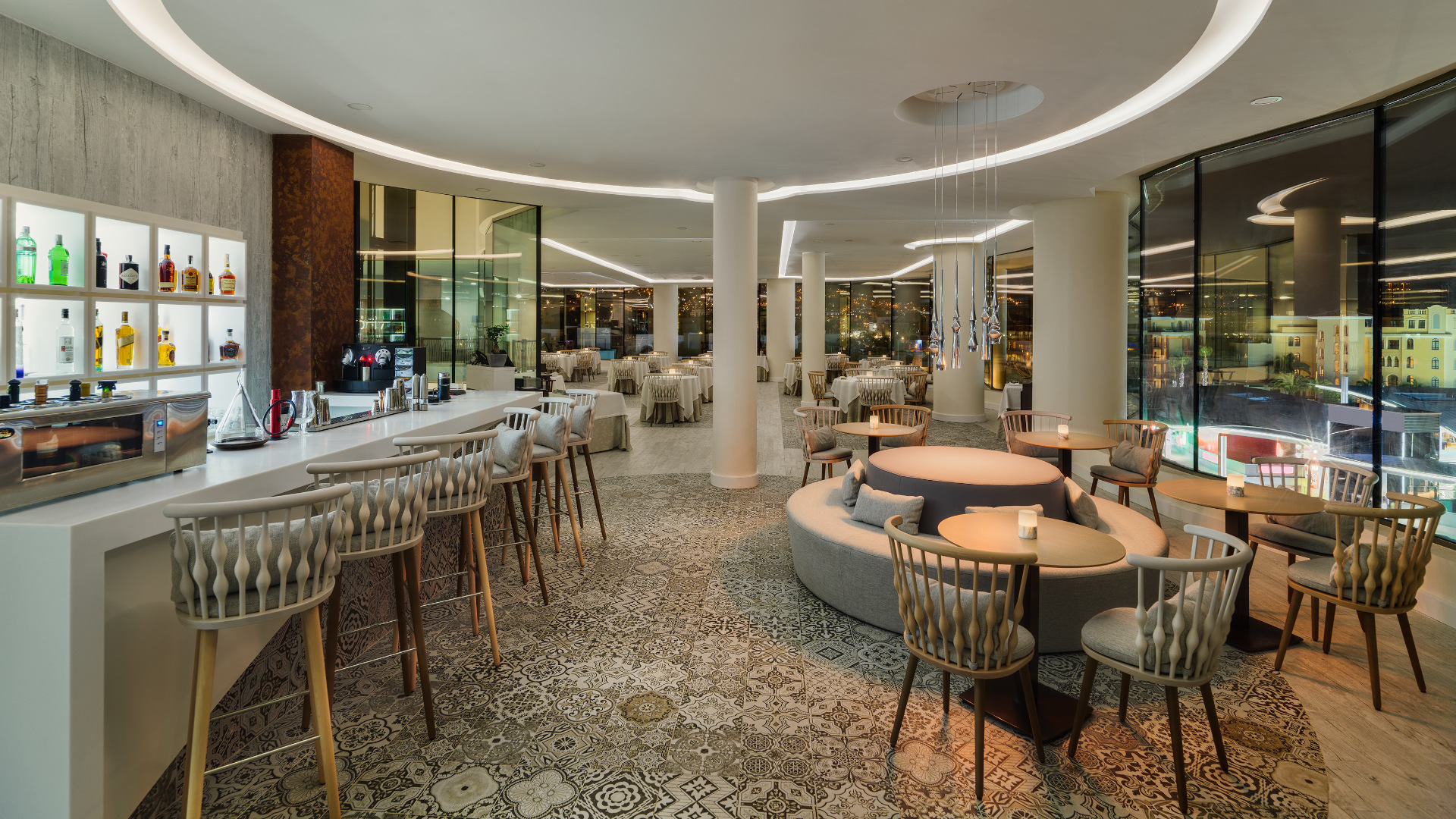Interior de un elegante restaurante en Tenerife, con barra iluminada y mesas con sillas.