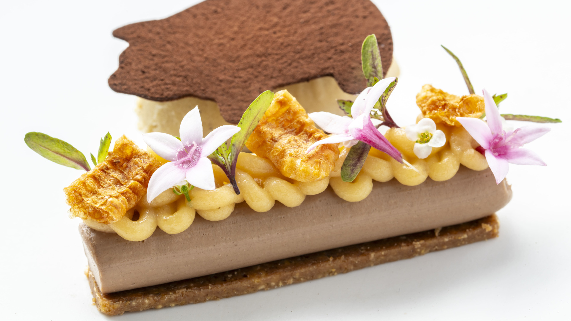 Postre decorado con flores y una oblea de chocolate en Tenerife.