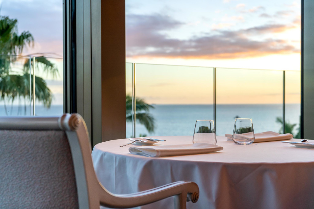 Mesa con copas y servilletas, vista al mar al atardecer en un lugar de Tenerife.