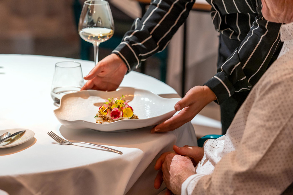 Sirviendo un elegante plato de comida en restaurante de Tenerife.