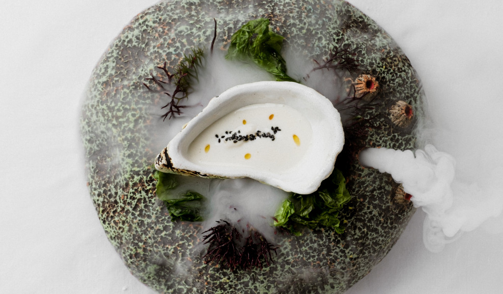 Plato de mariscos con crema blanca, algas y semillas en Tenerife.
