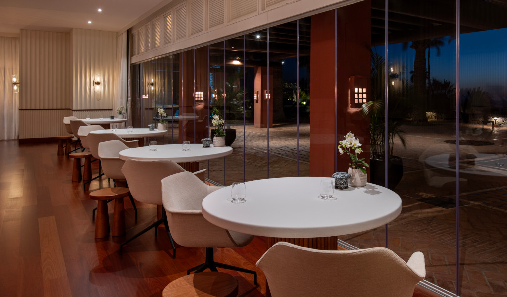 Mesas y sillas de comedor junto a ventanales en un restaurante elegante en Tenerife.