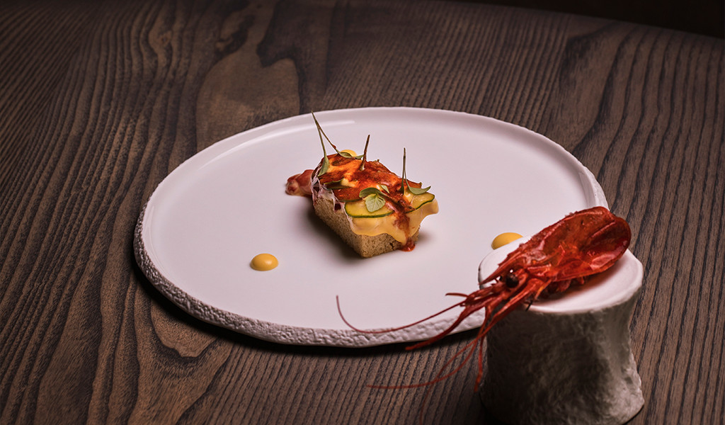 Gamba roja y aperitivo gourmet en plato sobre mesa de madera en Tenerife.