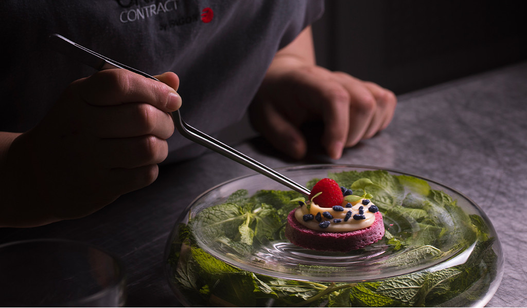 Decoración de postre con pinzas en un plato con hojas de menta en Tenerife.