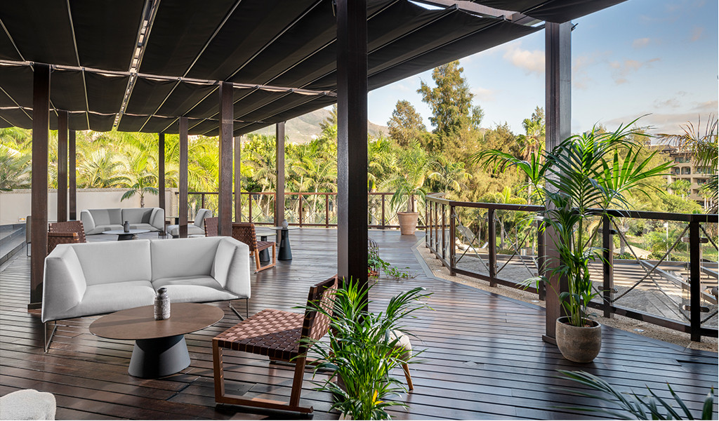 Terraza con muebles de exterior rodeada de plantas tropicales en Tenerife.