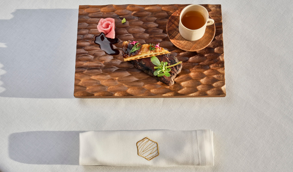 Plato de carne con guarnición y taza de bebida sobre mesa en Tenerife.