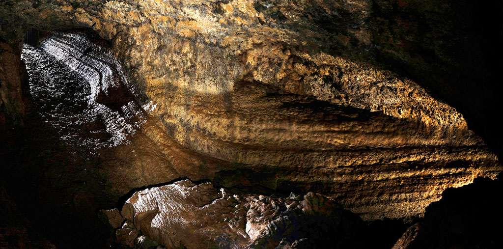 Interior de la Cueva del Viento en Tenerife, mostrando formaciones rocosas iluminadas.