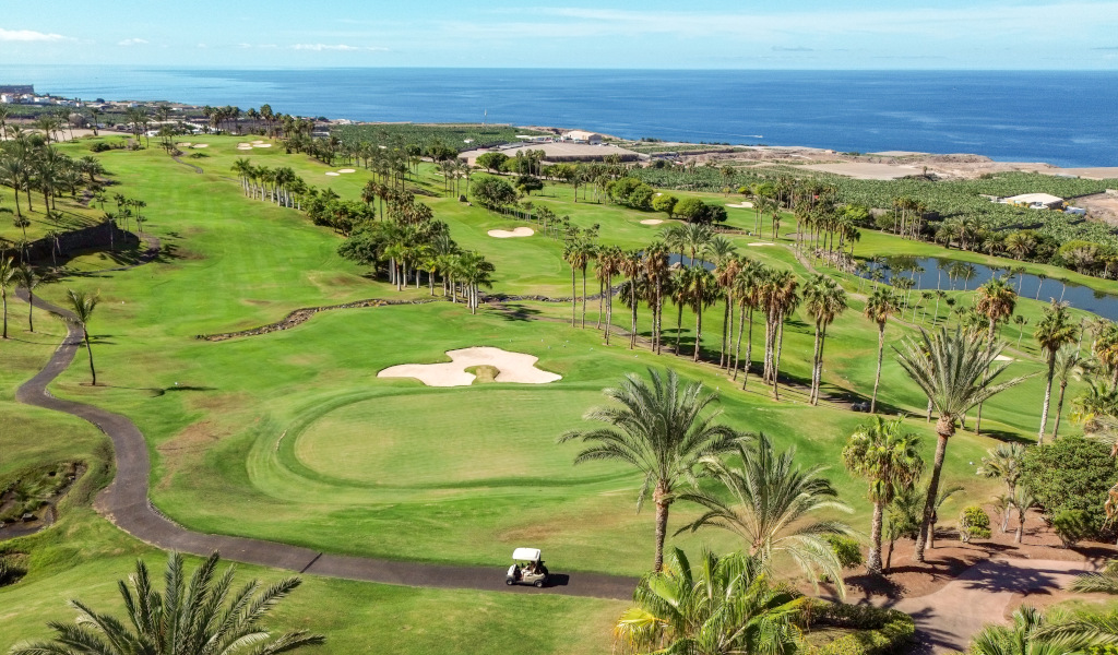 Campo de golf con palmeras junto al mar en Costa Adeje, Tenerife.