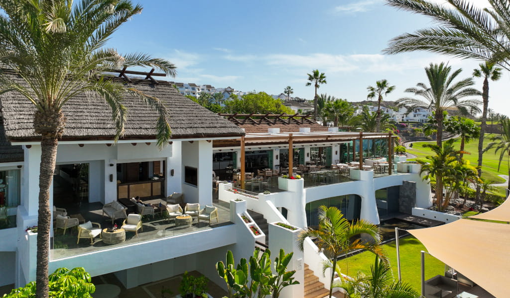 Terraza de restaurante rodeada de palmeras en Tenerife.