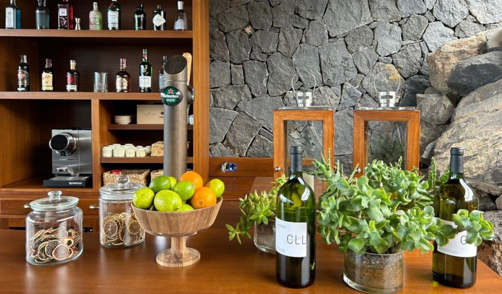 Bar de piedra con bebidas, café Nespresso, frutas y plantas en sitio en Tenerife.