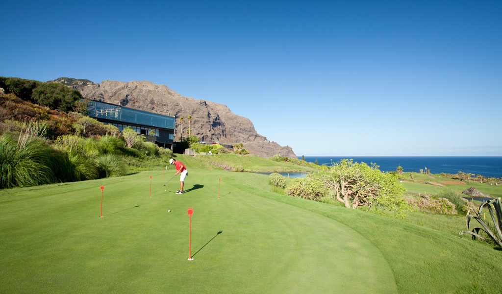 Jugador de golf en el campo frente a los acantilados de Los Gigantes, Tenerife.