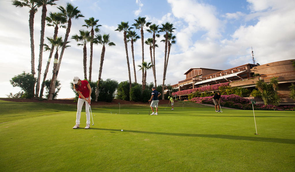 Jugadores de golf en un campo rodeado de palmeras en Tenerife.