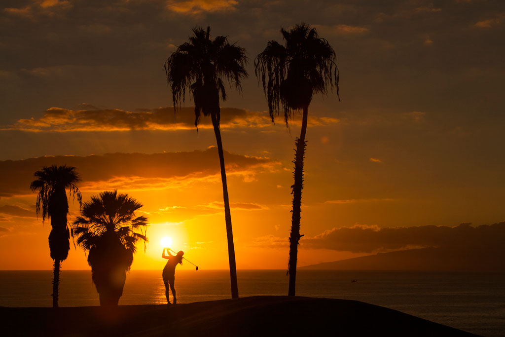 Atardecer con palmeras y persona jugando golf en Tenerife.