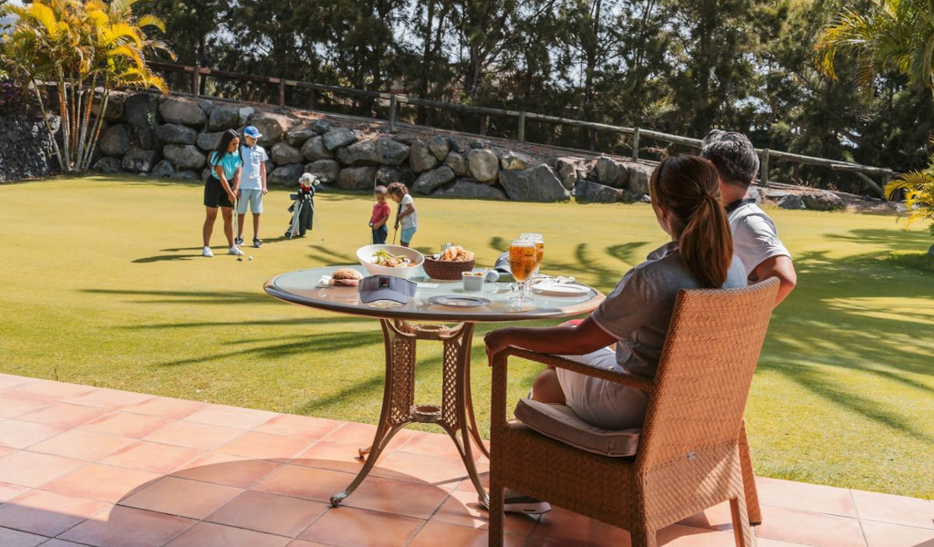 Personas jugando al golf y comiendo en un club en Tenerife.