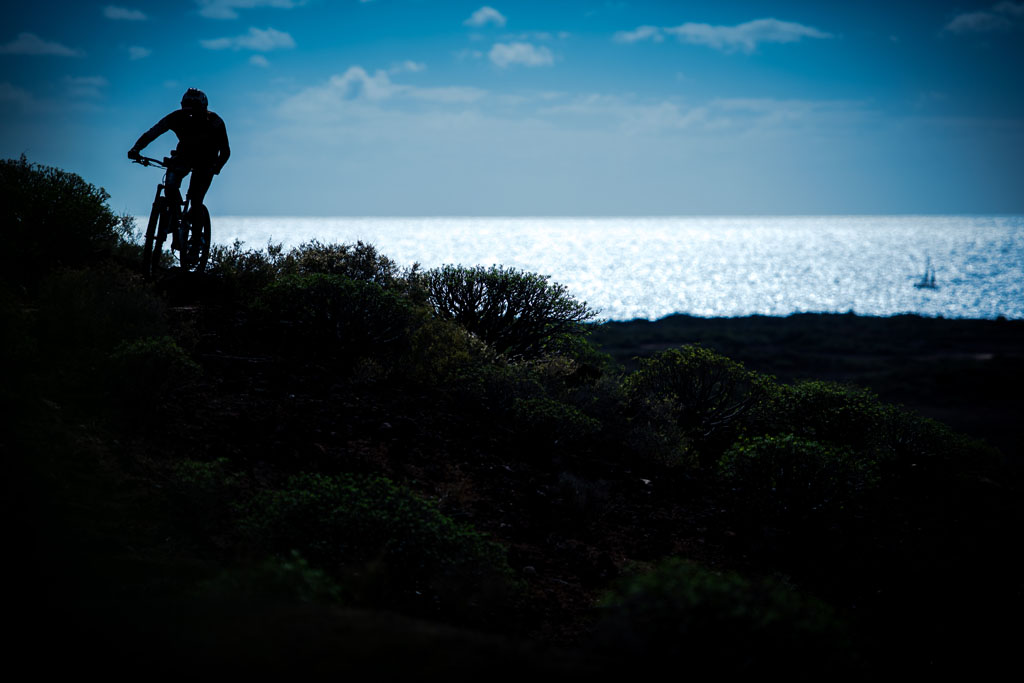 Ciclista en sendero costero con vista al mar en Tenerife.