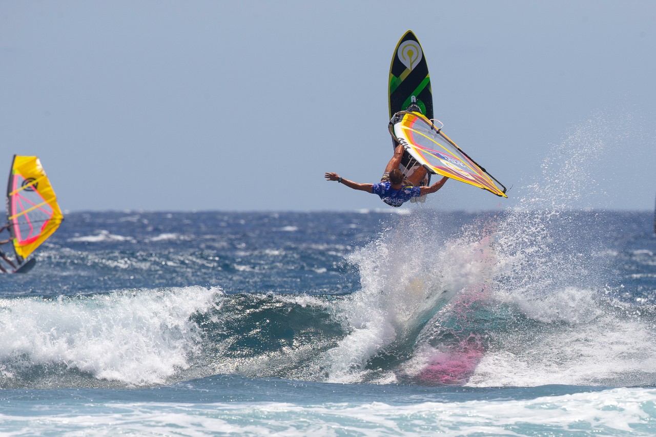 Persona practicando windsurf en el mar de Tenerife, realizando un salto sobre el agua.