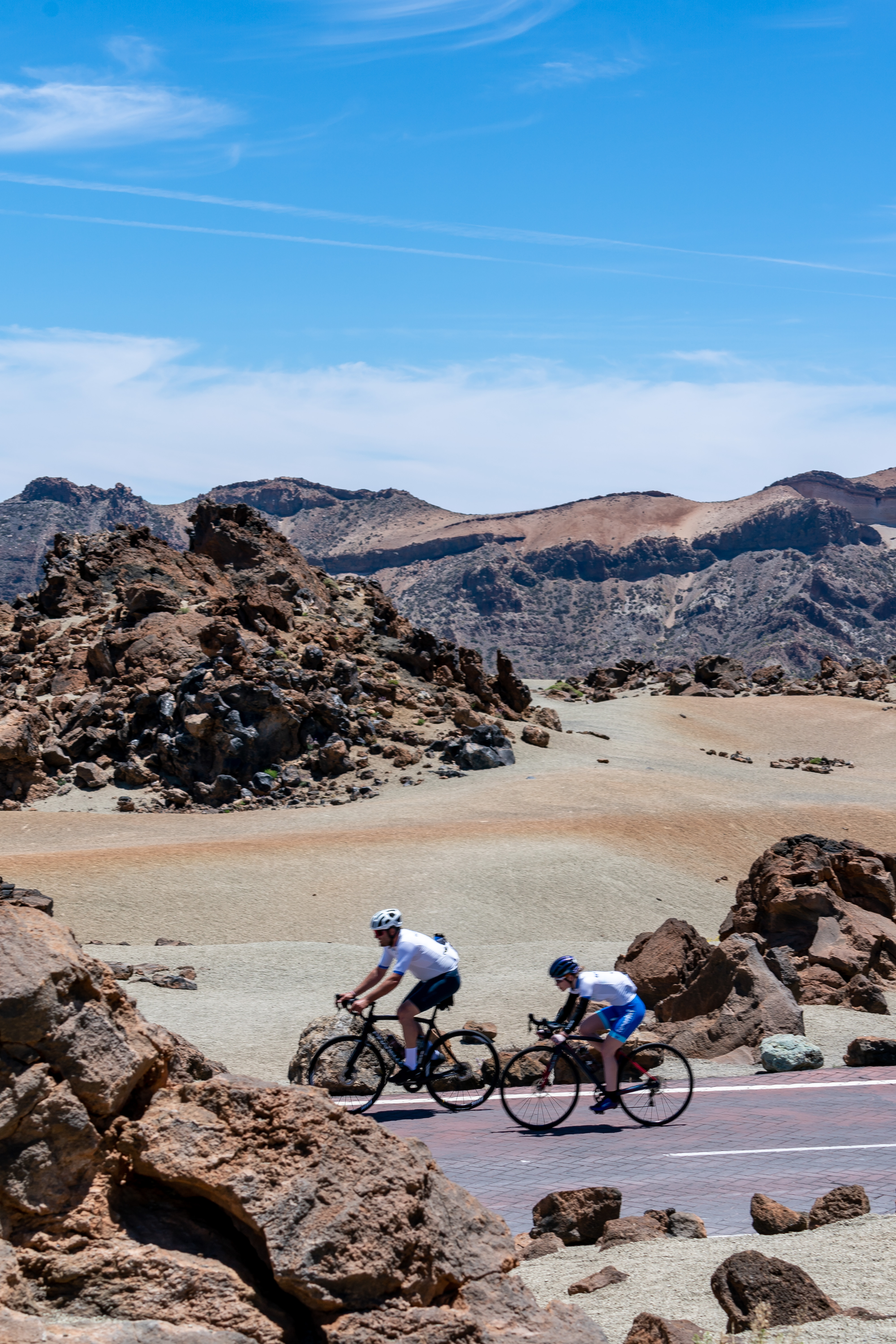 Ciclistas recorriendo el paisaje volcánico en Parque Nacional del Teide, Tenerife.