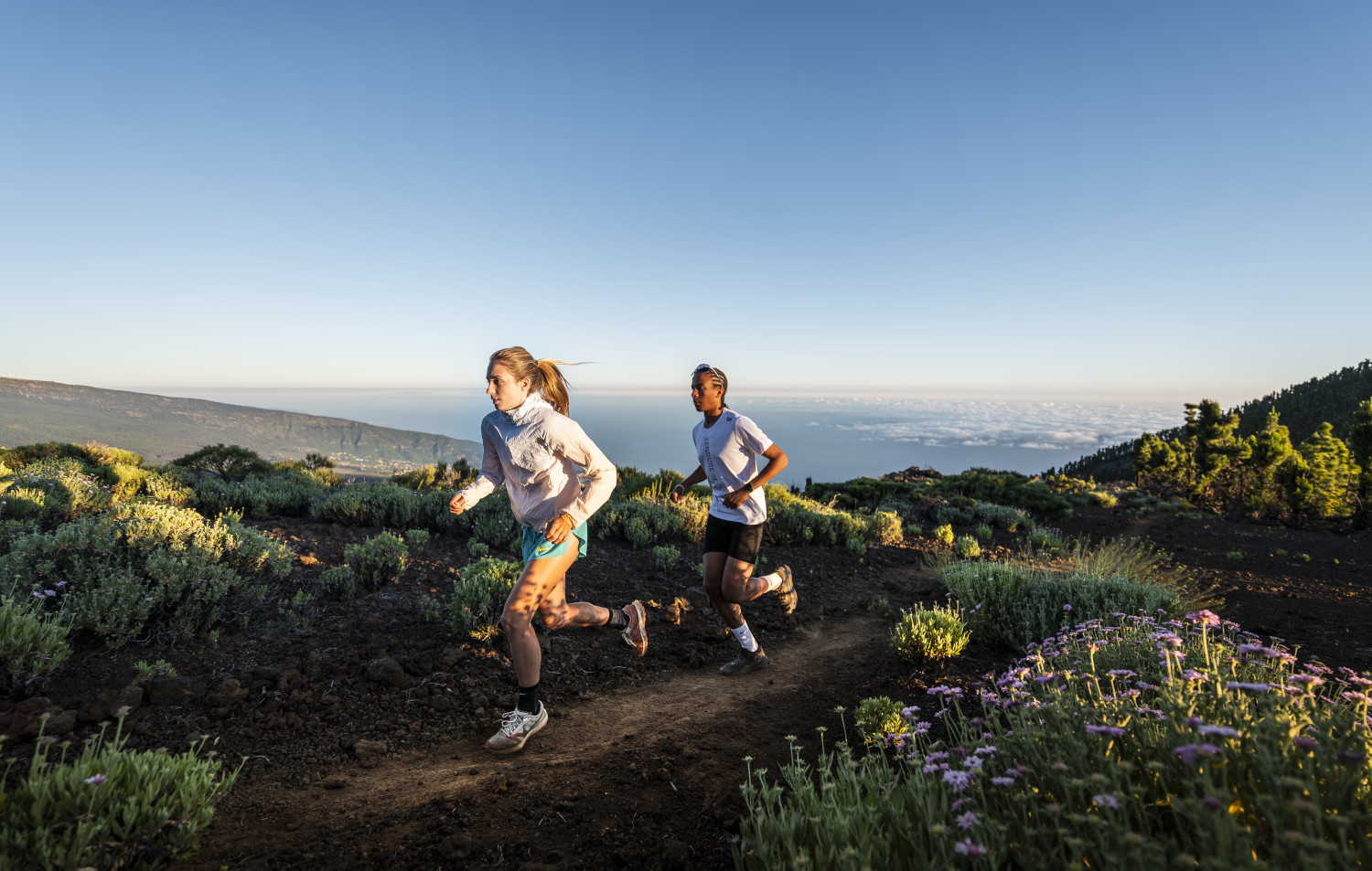 Personas corriendo por sendero con vistas al mar en Tenerife.