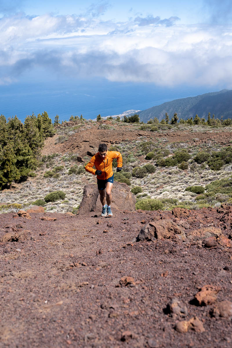 Persona corriendo en un sendero montañoso en Tenerife con vistas al mar.