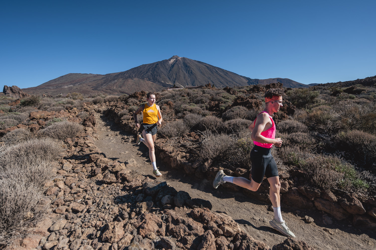 Corredores en sendero del Teide, Tenerife, con el volcán de fondo.
