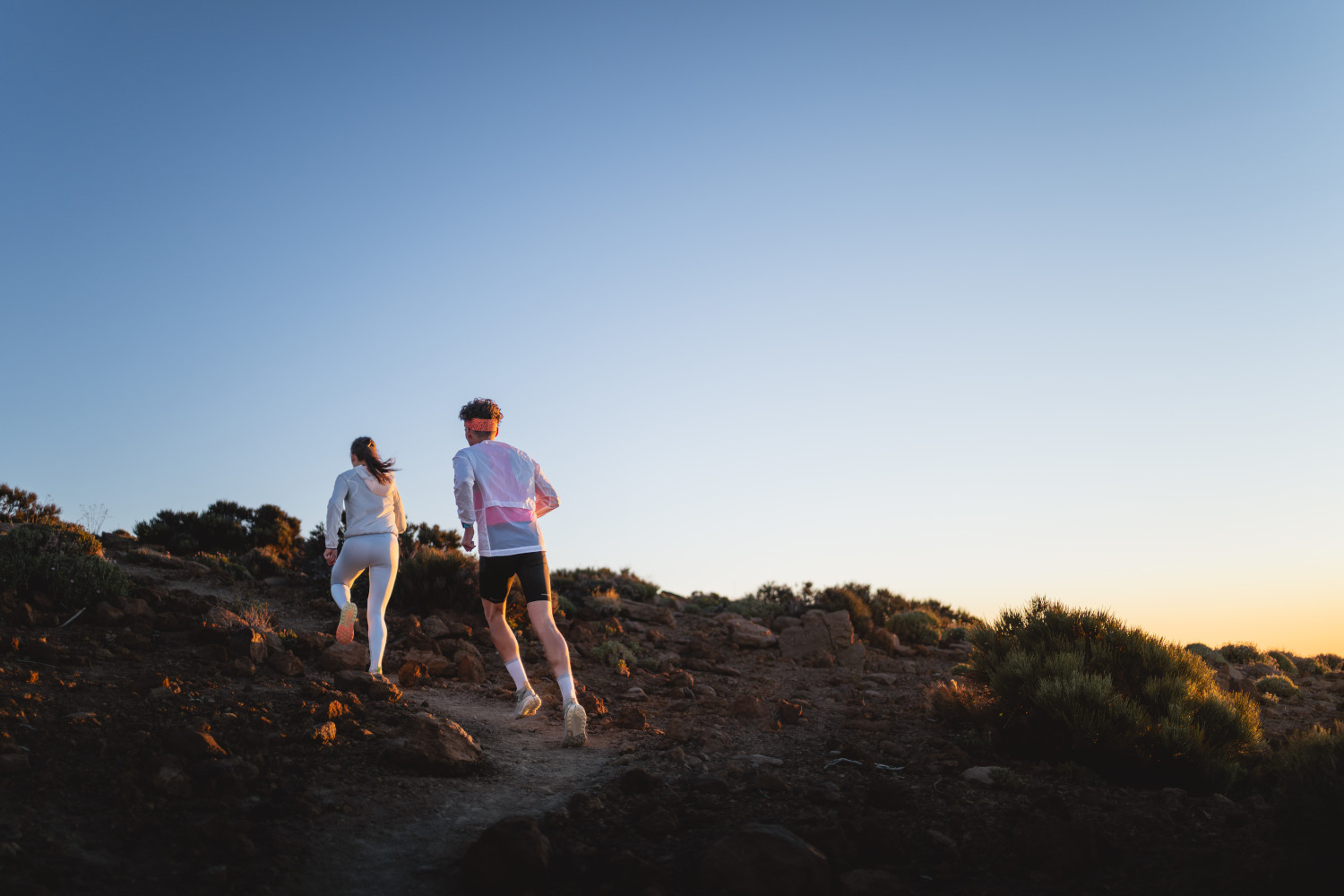 Dos personas corren al amanecer por un sendero en Tenerife.