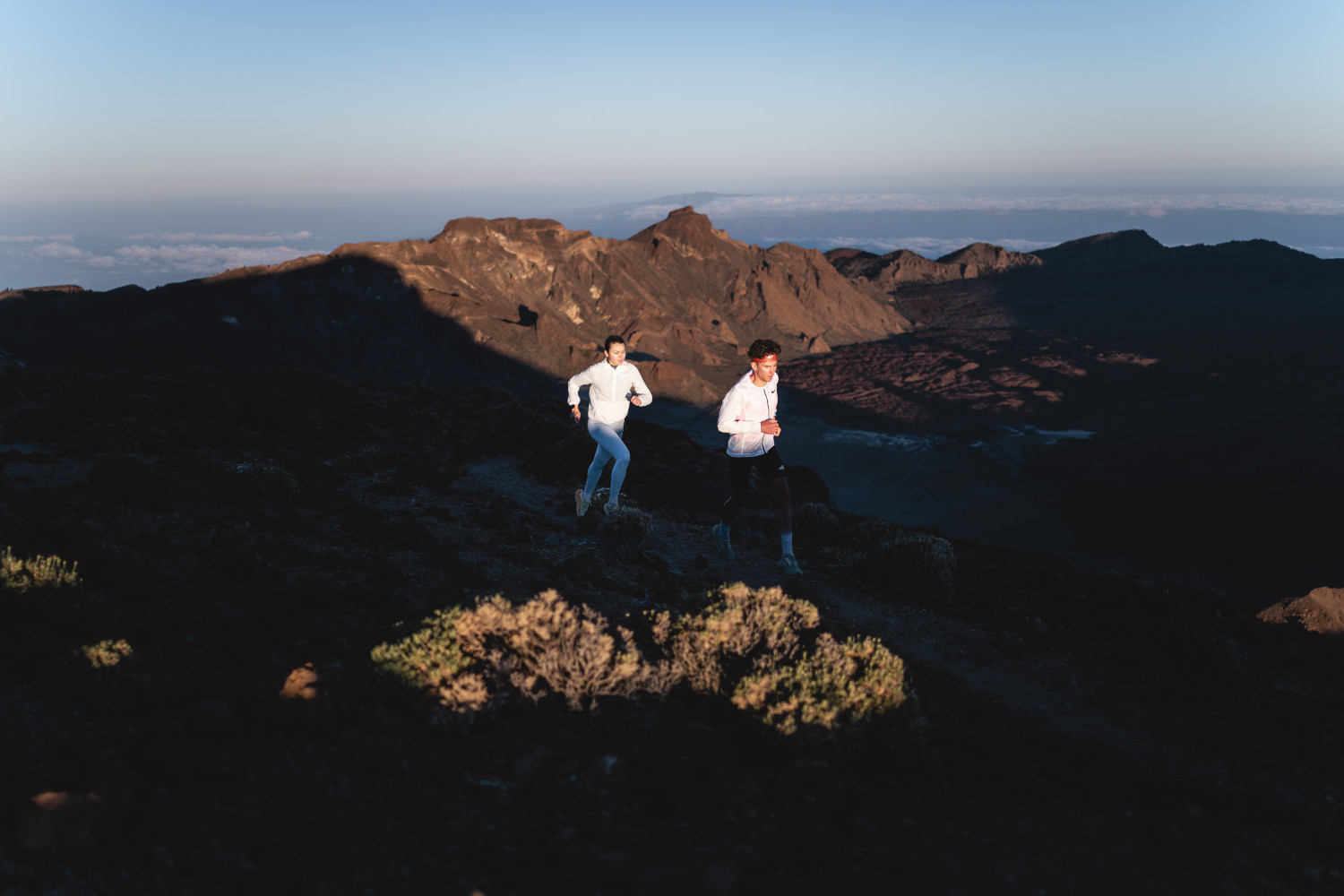 Dos personas corriendo al amanecer en el Parque Nacional del Teide, Tenerife.