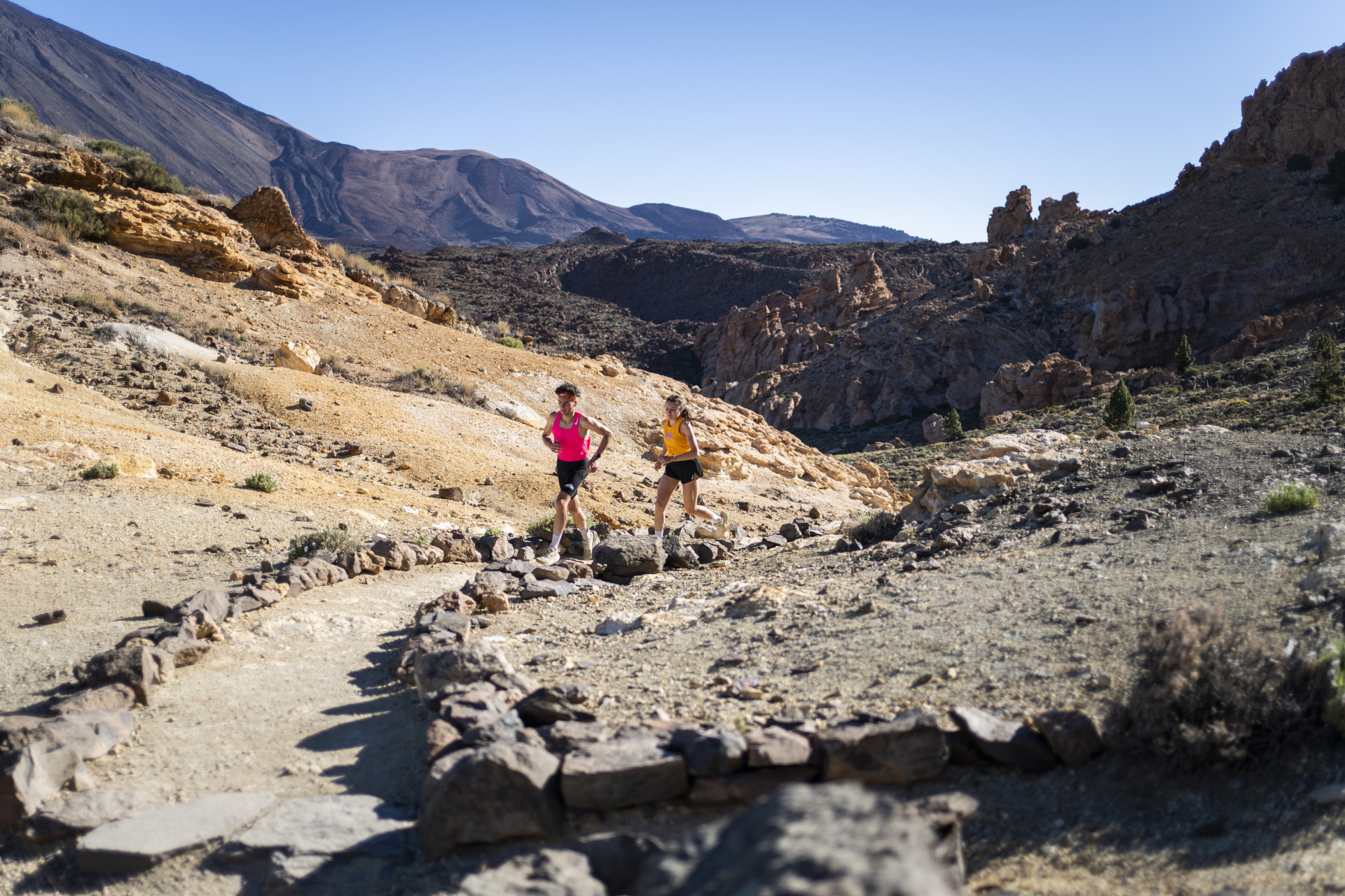 Dos personas corriendo en un sendero del Parque Nacional del Teide, Tenerife.