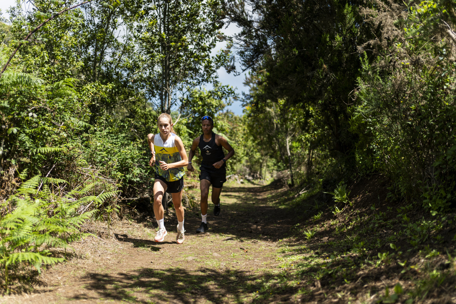 Corredores en un sendero rodeado de vegetación en La Laguna, Tenerife.