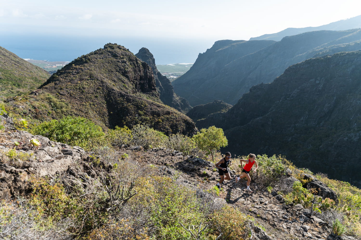 Sendero en las montañas de Tenerife con dos personas corriendo.
