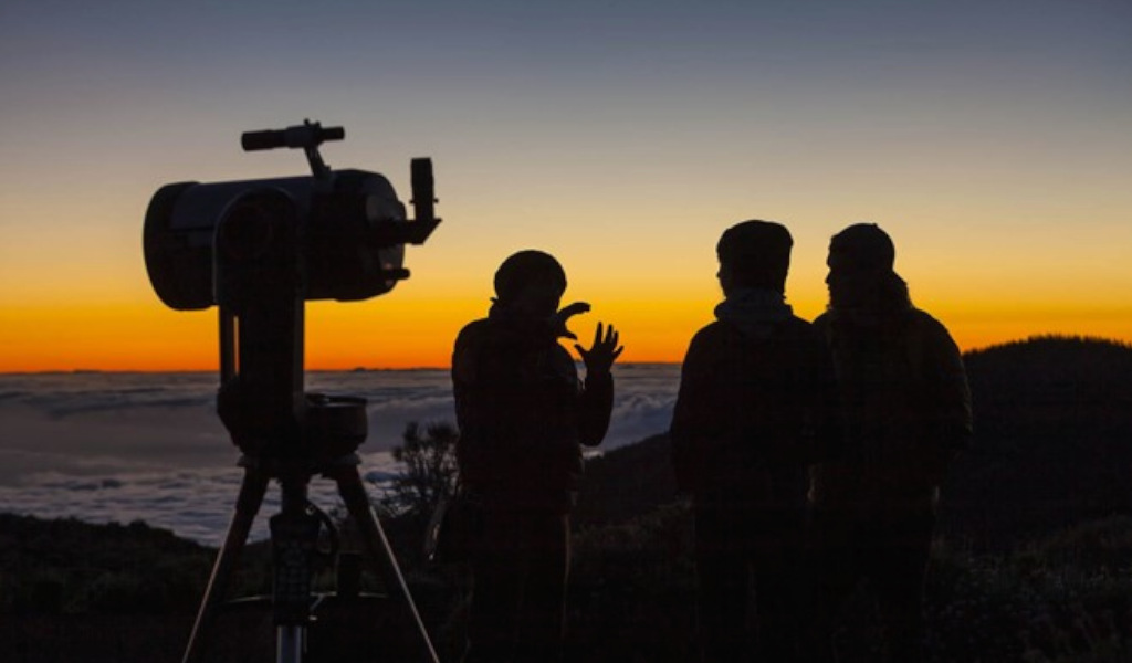 Personas observando el amanecer con telescopio en Tenerife.