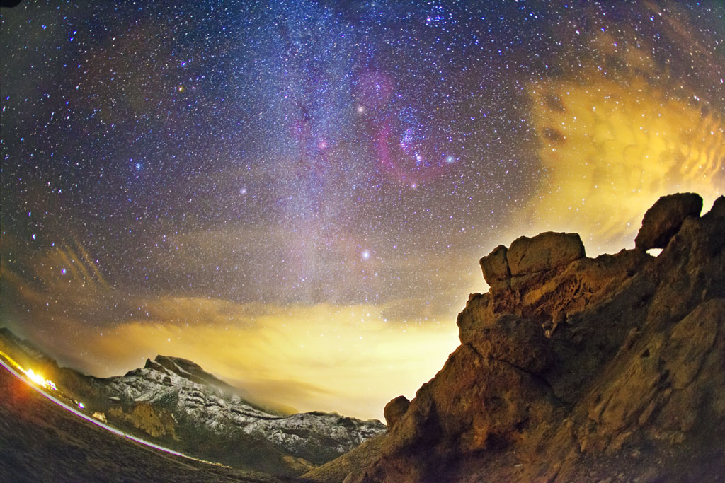 Cielo estrellado sobre rocas en paisaje nocturno del Parque Nacional del Teide, Tenerife.
