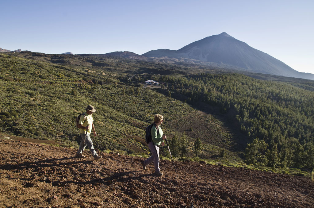 Senderistas en el Parque Nacional del Teide, Tenerife, con fondo de volcán.