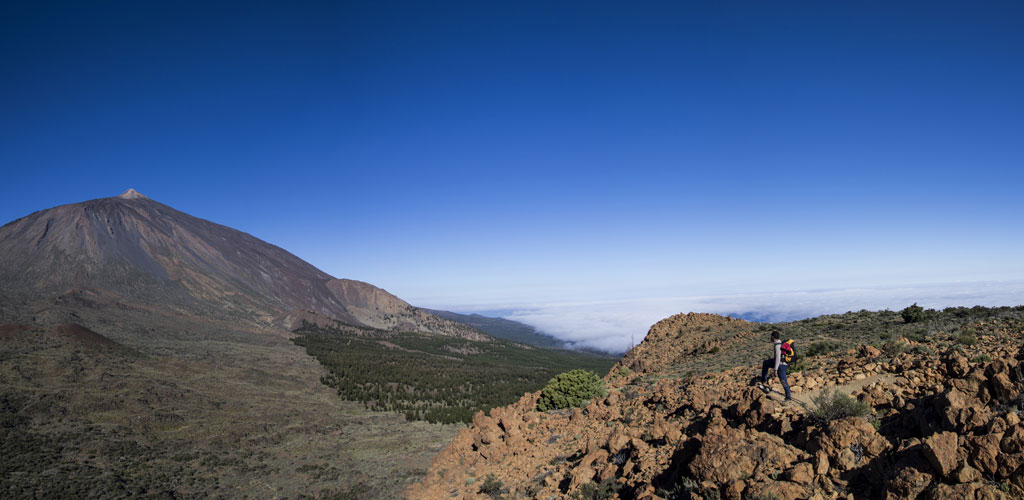 Senderista en el Parque Nacional del Teide, Tenerife, con el volcán de fondo.