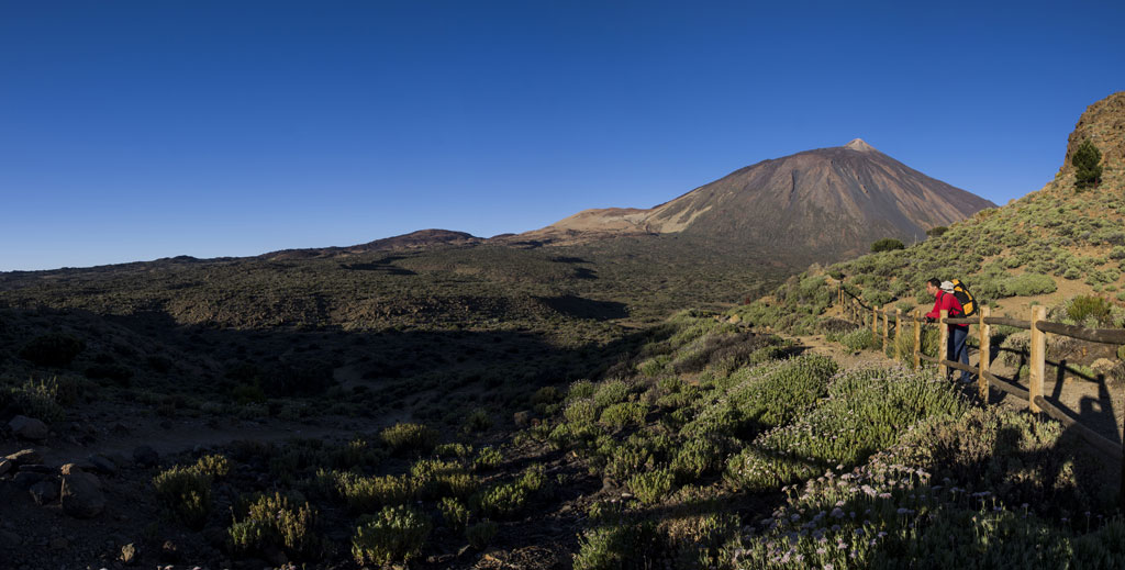 Sendero con montañista y vista del Teide en Tenerife.