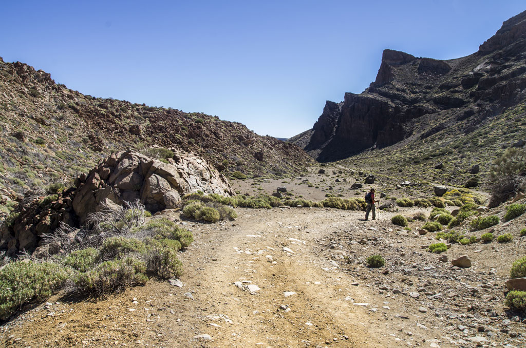 Sendero de montaña en Parque Nacional del Teide, Tenerife, con excursionista caminando.