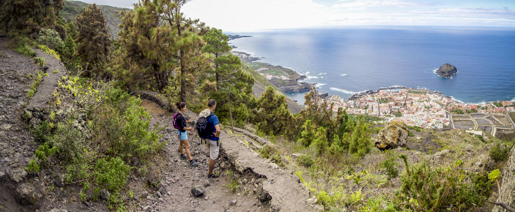 Sendero con vistas al mar y un pueblo en Tenerife, visto desde la montaña.