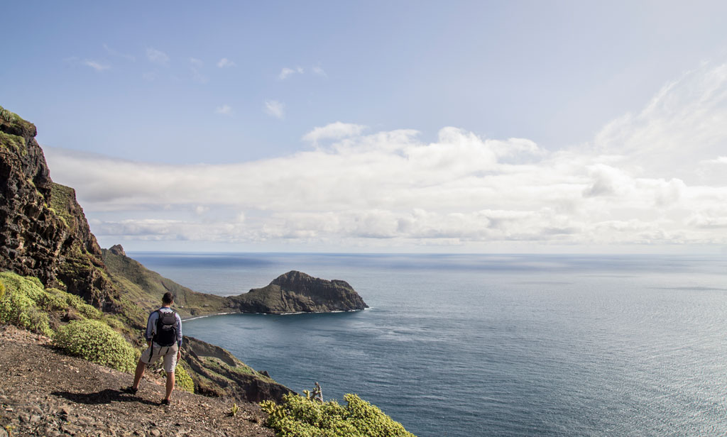 Senderista en acantilado con vista al mar en Tenerife.